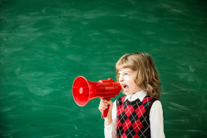 Back to school. Schoolchild in class. Happy kid against green blackboard. Education and creativity concept