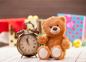 Alarm clock and teddy bear on christmas background