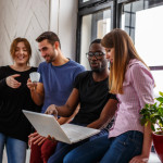 Group of international students using laptop.