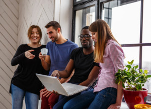 Group of international students using laptop.