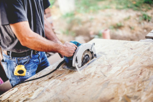 Industrial worker Using Circular Saw on wooden board in Carpentry Workshop