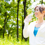 young asian woman with drinking water in the park