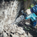 Industrial equipment close up. Construction worker using pneumatic machinery, drilling tool