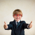 Portrait of young happy businessman showing thumbs up. Success and creative concept. Copy space for your text